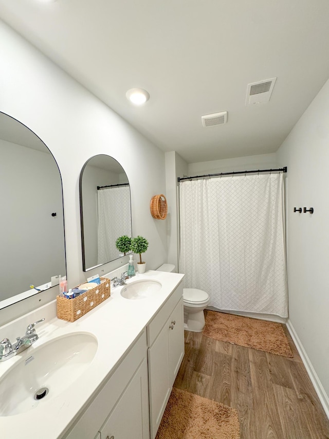 bathroom featuring toilet, wood-type flooring, and vanity