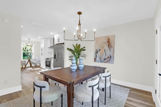 dining space featuring recessed lighting, wood finished floors, visible vents, baseboards, and a notable chandelier