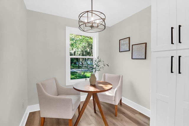 dining room with baseboards, a chandelier, and light wood finished floors