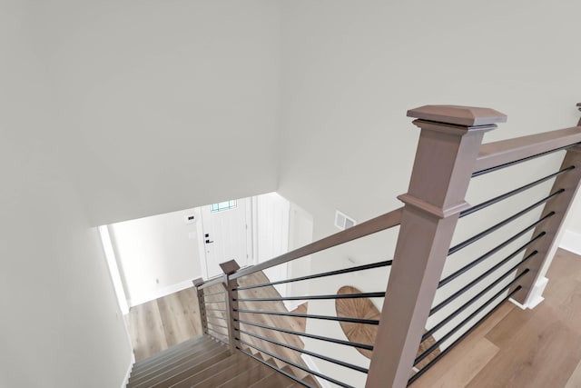 staircase featuring visible vents and wood finished floors