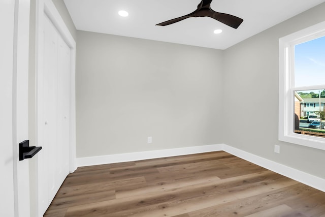 unfurnished bedroom with recessed lighting, baseboards, wood finished floors, and a closet