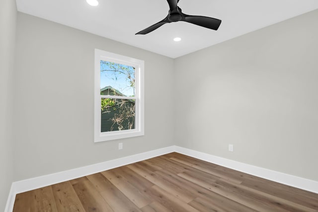 spare room featuring recessed lighting, wood finished floors, a ceiling fan, and baseboards