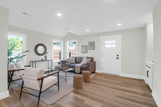 living room featuring baseboards, a healthy amount of sunlight, and light wood-type flooring