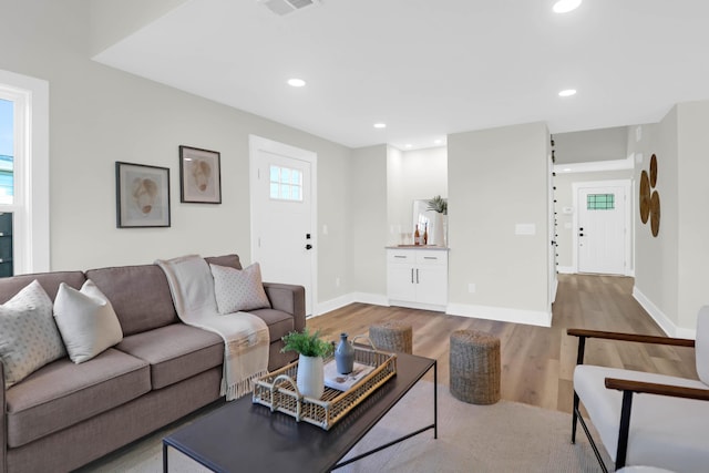 living room featuring baseboards, wood finished floors, visible vents, and recessed lighting
