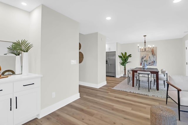 dining area with a chandelier, light wood-style flooring, baseboards, and recessed lighting