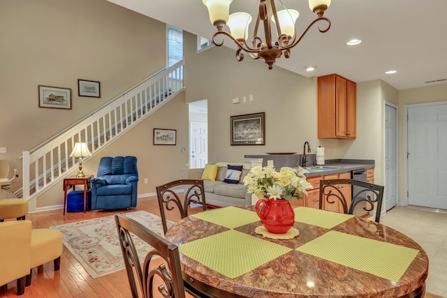 dining area with an inviting chandelier, light hardwood / wood-style flooring, and sink