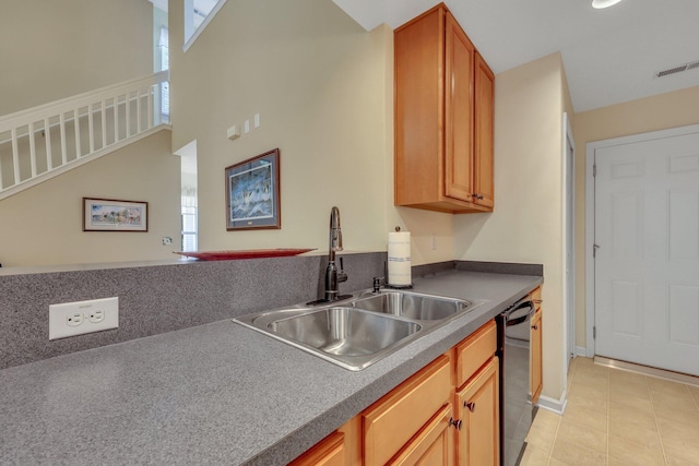 kitchen featuring plenty of natural light, light tile patterned floors, black dishwasher, and sink