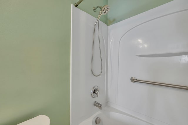 bathroom featuring washtub / shower combination and toilet