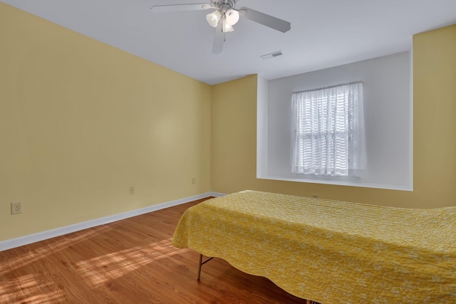 bedroom with hardwood / wood-style floors and ceiling fan