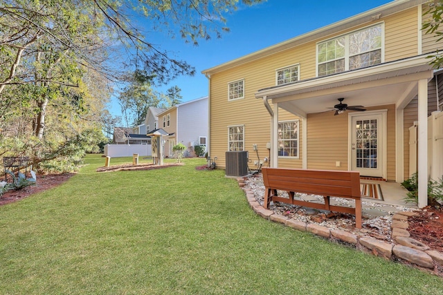 back of property with ceiling fan, central AC unit, and a yard