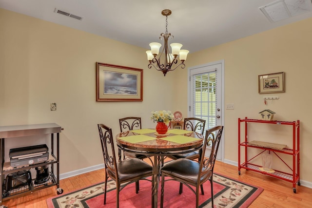 dining room featuring a notable chandelier and light hardwood / wood-style flooring