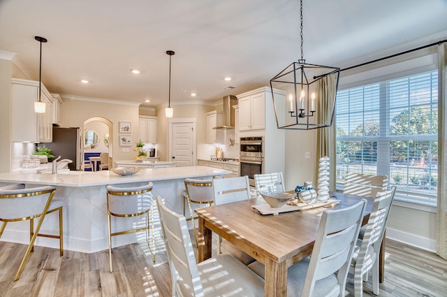 dining space with light wood-style floors, baseboards, crown molding, and recessed lighting