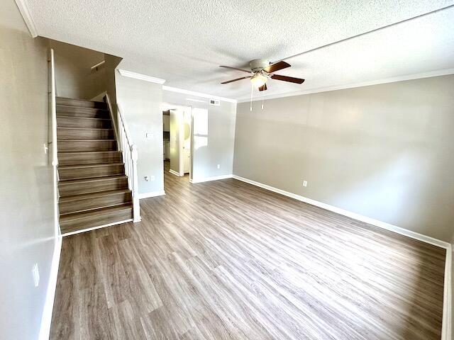 1820 Mepkin Rd Unit 1019, Charleston, SC 29407 - unfurnished living room with ceiling fan, ornamental molding, stairway, wood finished floors, and a textured ceiling