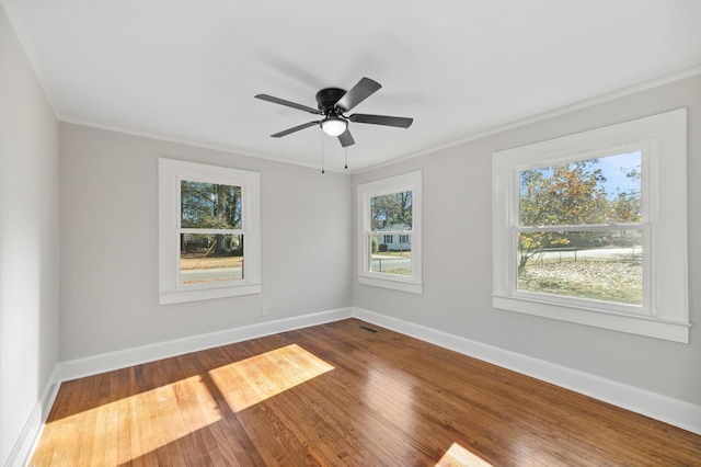 unfurnished room with hardwood / wood-style flooring, ceiling fan, a healthy amount of sunlight, and crown molding