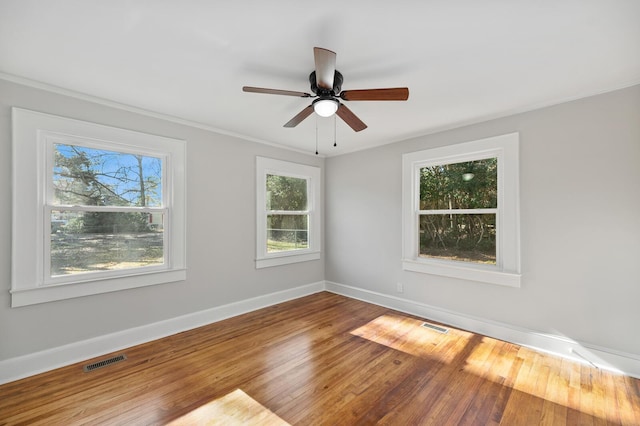 unfurnished room with ceiling fan, a healthy amount of sunlight, and wood-type flooring