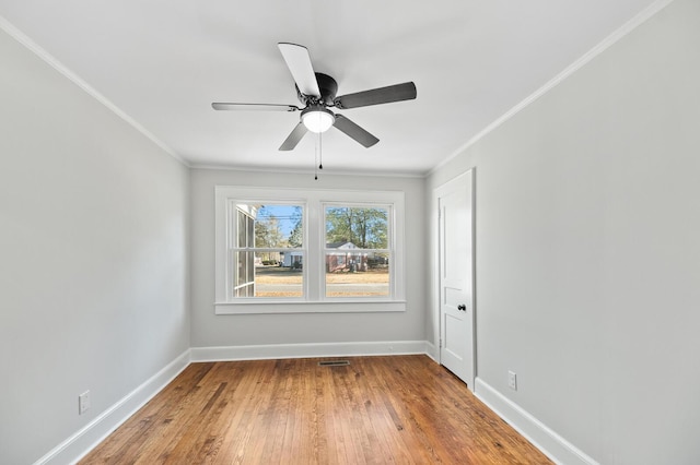 spare room featuring hardwood / wood-style flooring, ceiling fan, and ornamental molding