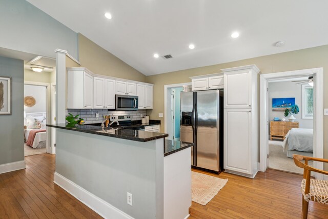 8 Tovey Rd, Charleston, SC 29407 - kitchen featuring stainless steel appliances, white cabinets, decorative backsplash, light wood finished floors, and a peninsula