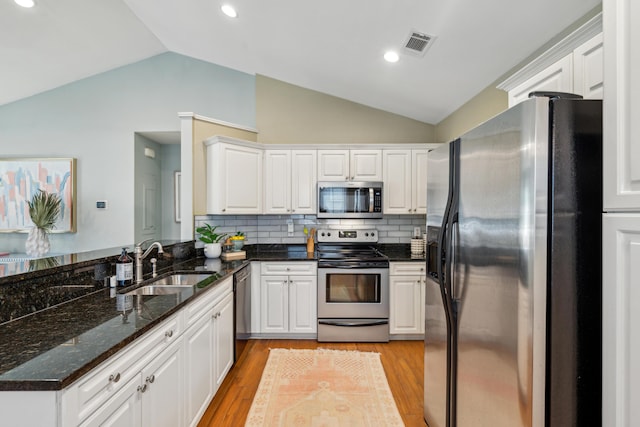 8 Tovey Rd, Charleston, SC 29407 - kitchen featuring stainless steel appliances, lofted ceiling, light wood finished floors, a peninsula, and white cabinets