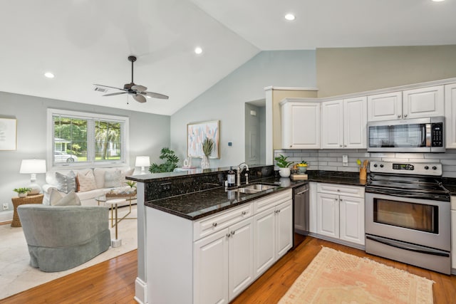 8 Tovey Rd, Charleston, SC 29407 - kitchen featuring stainless steel appliances, open floor plan, vaulted ceiling, a peninsula, and white cabinetry