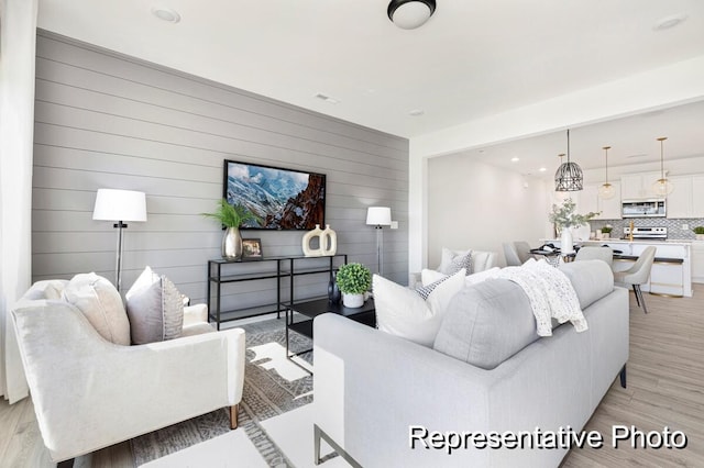 living room featuring wood walls and light hardwood / wood-style flooring