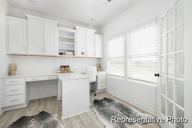 office space featuring built in desk and light hardwood / wood-style floors