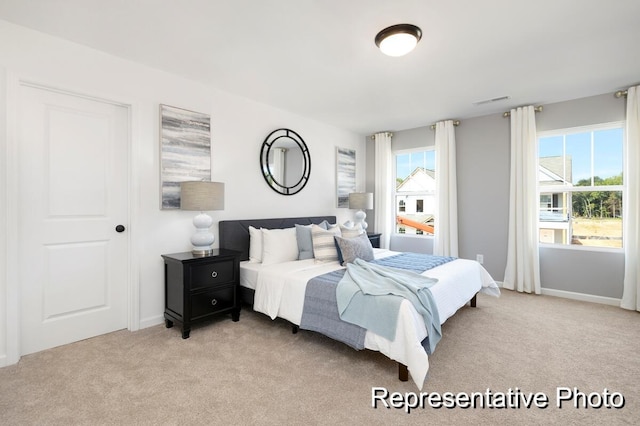 carpeted bedroom featuring multiple windows