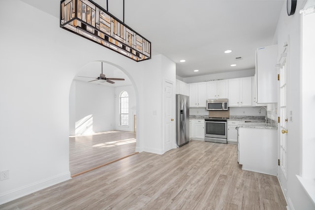 kitchen featuring stainless steel appliances, ceiling fan, sink, light hardwood / wood-style flooring, and white cabinets