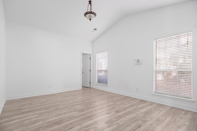 spare room featuring light hardwood / wood-style floors and vaulted ceiling