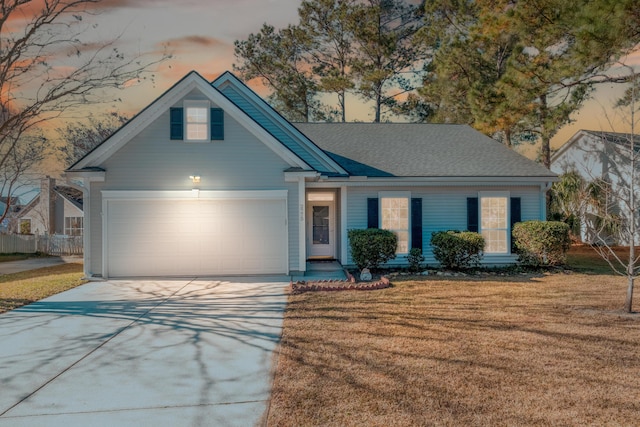 view of front facade with a yard and a garage