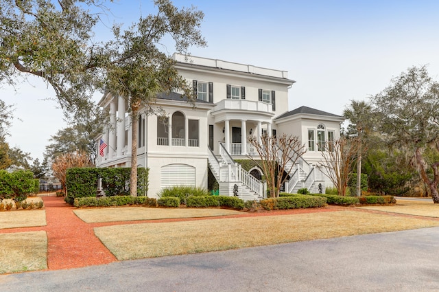 view of front of home with a balcony and a front lawn