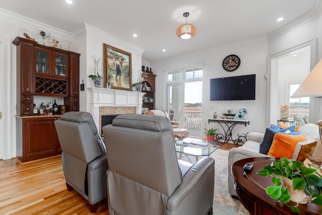 living room featuring crown molding, light hardwood / wood-style flooring, and a wealth of natural light