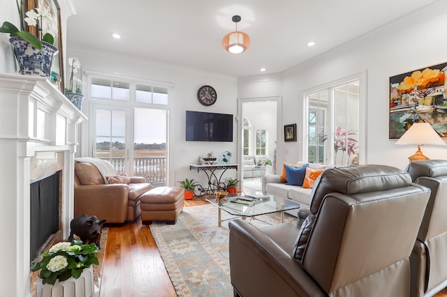 living room with ornamental molding, light hardwood / wood-style floors, and a fireplace