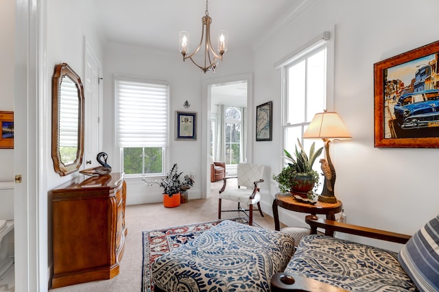 sitting room with a notable chandelier, ornamental molding, and light carpet