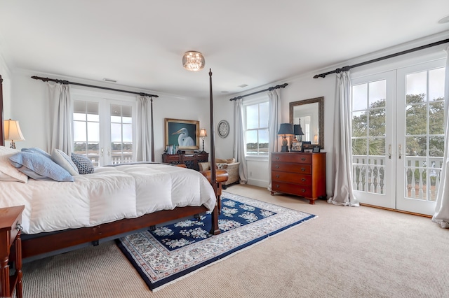 carpeted bedroom with access to exterior, multiple windows, and french doors