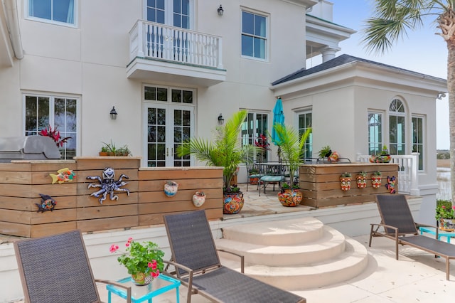 view of patio with area for grilling and a balcony