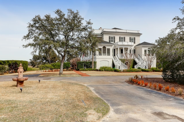 view of front facade with a balcony and a front lawn