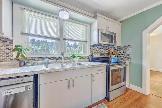 1314 Cooper Store Rd, Moncks Corner, SC 29461 - kitchen featuring appliances with stainless steel finishes, a sink, ornamental molding, light countertops, and light wood finished floors