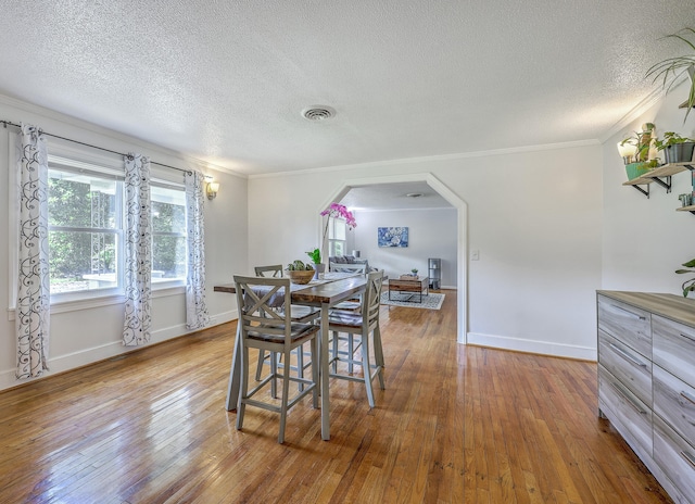 1314 Cooper Store Rd, Moncks Corner, SC 29461 - dining room with arched walkways, a textured ceiling, crown molding, hardwood / wood-style flooring, and baseboards