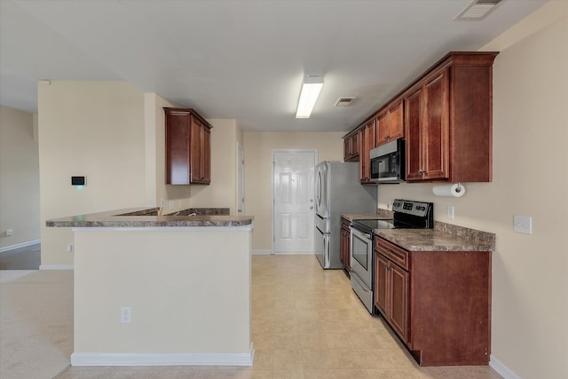 kitchen with stainless steel appliances, visible vents, a peninsula, and baseboards