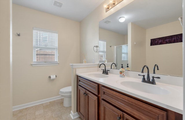 full bathroom with visible vents, a sink, a shower stall, and toilet