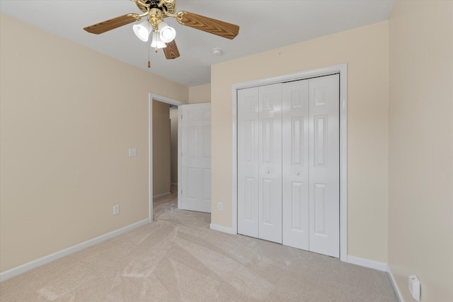 unfurnished bedroom with baseboards, a closet, a ceiling fan, and light colored carpet