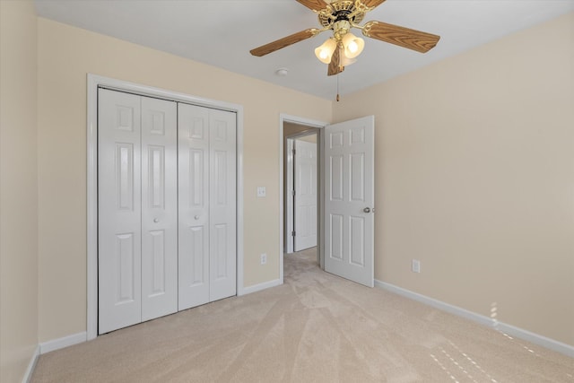 unfurnished bedroom featuring baseboards, a closet, a ceiling fan, and light colored carpet