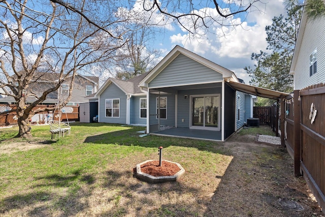 rear view of house featuring a patio, a lawn, and a fenced backyard