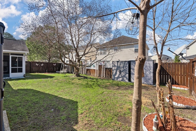 view of yard with a sunroom and a fenced backyard