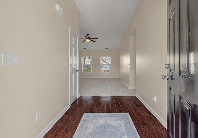 hallway featuring wood finished floors and baseboards