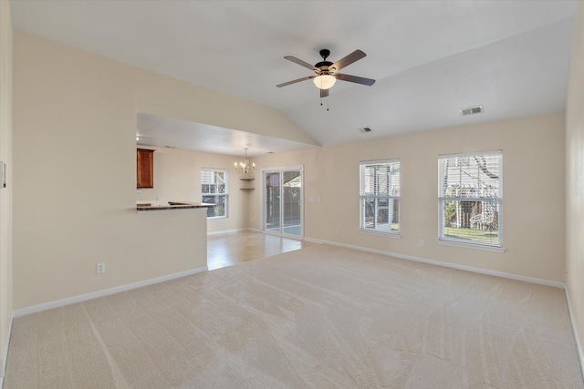 unfurnished living room featuring light carpet, ceiling fan with notable chandelier, visible vents, and baseboards