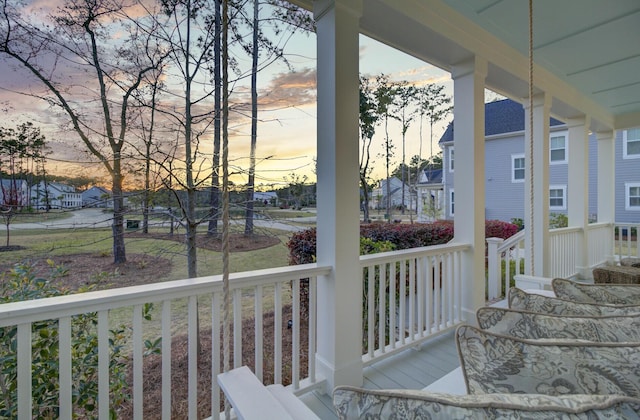 1098 Reserve Ln, Awendaw, SC 29429 - deck at dusk featuring covered porch and a residential view