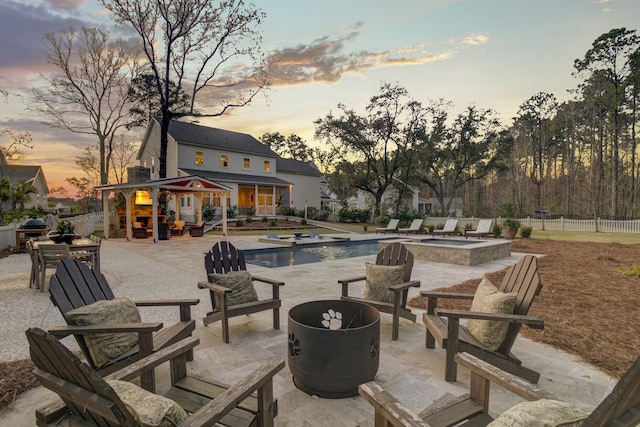 1098 Reserve Ln, Awendaw, SC 29429 - patio terrace at dusk with a fire pit, a patio area, a fenced backyard, and a pool with connected hot tub