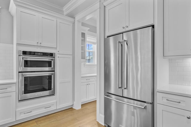1098 Reserve Ln, Awendaw, SC 29429 - kitchen featuring appliances with stainless steel finishes, ornamental molding, light wood-type flooring, decorative backsplash, and light countertops