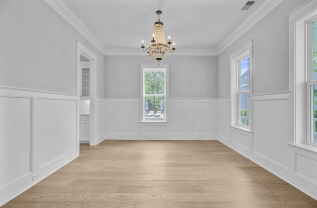1098 Reserve Ln, Awendaw, SC 29429 - unfurnished dining area with a chandelier, healthy amount of natural light, a decorative wall, light wood-style floors, and ornamental molding
